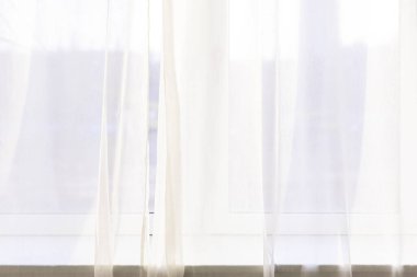 Yoga stüdyosunun pencerelerinin yanındaki beyaz tül. 
