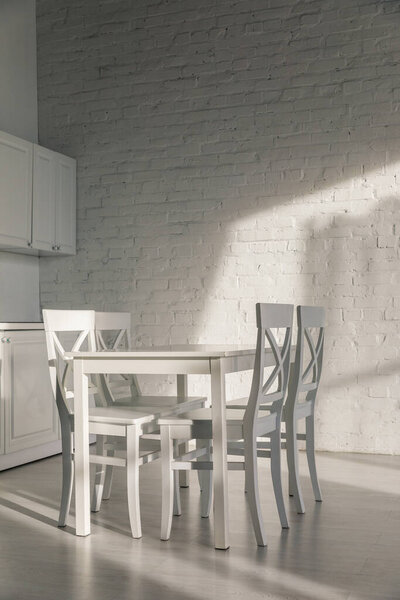 chairs and table near brick wall in modern kitchen 