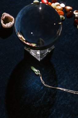 Kristal küre ve fal Koyu mavi kadife kumaş üzerinde taşlar söylüyor
