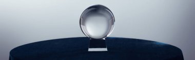 Crystal ball on round table on grey background, panoramic shot clipart