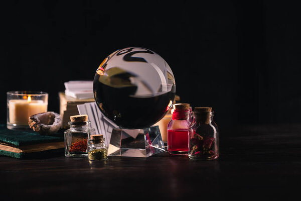 Selective focus of occult and mystical objects on wooden and black background