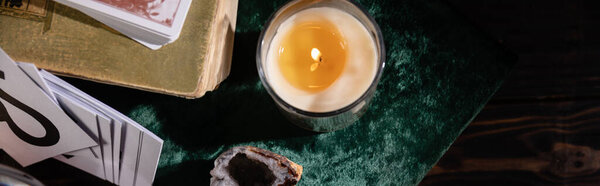 КИЕВ, УКРАИНА - 9 ЯНВАРЯ 2020: вид сверху на свечи, книги и открытки на деревянном фоне, панорамный снимок
