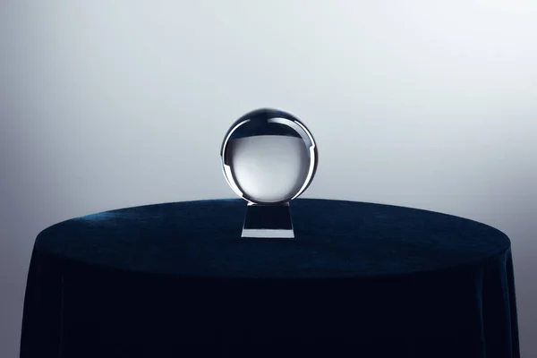 灰色の背景に丸いテーブルの上のクリスタルボール — ストック写真