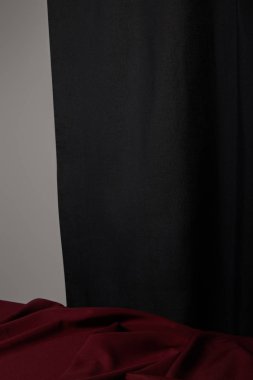 Burgundy yumuşak ve buruşuk kumaş. Gri üzerine izole edilmiş siyahın yanında.