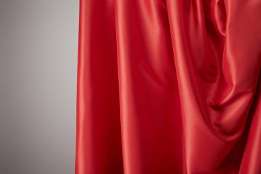 Gri arkaplanda kırmızı yumuşak ve dalgalı ipek kumaş görünümünü kapat