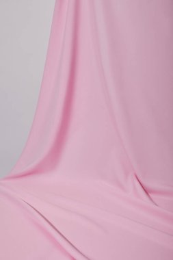 close up view of pink soft wavy fabric isolated on grey clipart