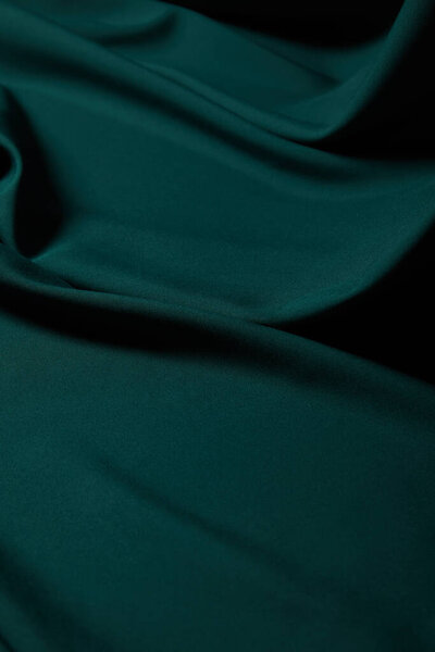 close up view of emerald soft and wavy silk fabric