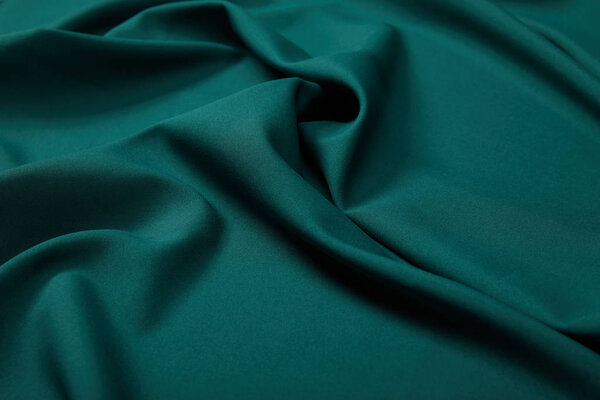 close up view of emerald soft and wavy silk fabric