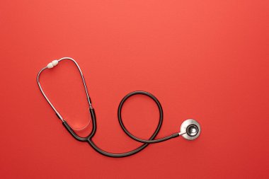 Top view of stethoscope on red background clipart