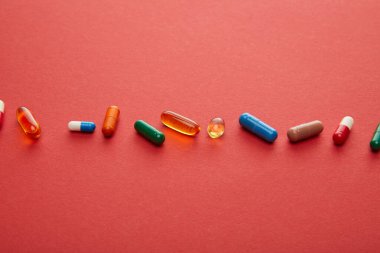 Kırmızı arkaplanda hapların yüksek açılı görünümü