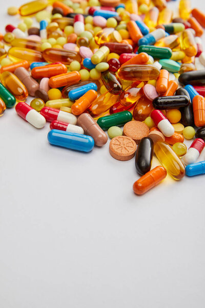 Selective focus of bright capsules and pills on white background
