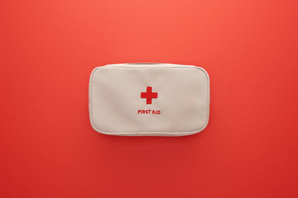 Top view of first aid kit isolated on red