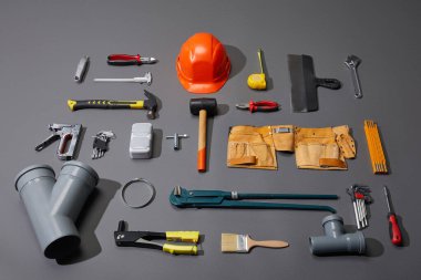 flat lay with industrial tools, helmet, and tool belt on grey background clipart