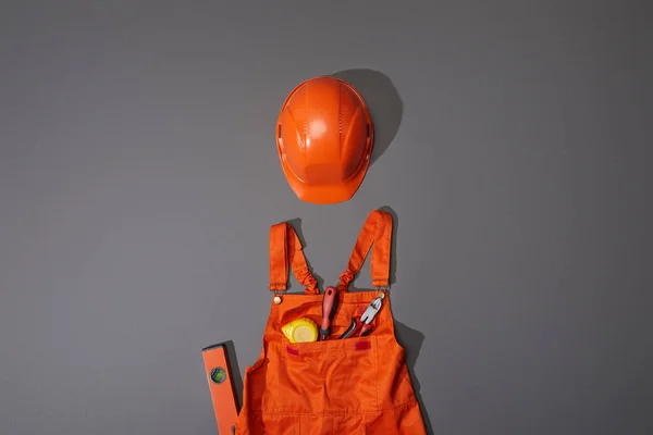 Верхний Вид Оранжевого Шлема Комбинезона Измерительной Лентой Отверткой Плоскогубцами Сером — стоковое фото