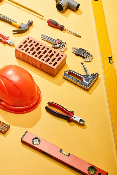Flat Lay Industrial Tools Brick Helmet Yellow Background — Stock Photo, Image