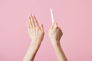 Pembe üzerinde tırnak törpüsü olan kadın elleri.