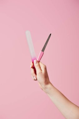 Pembe üzerinde tırnak törpüsü tutan kadın görüntüsü.