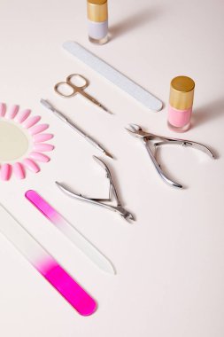 High angle view of bottles and samples of nail polish near manicure instruments on white clipart