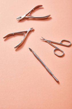 High angle view of manicure instruments on coral background clipart