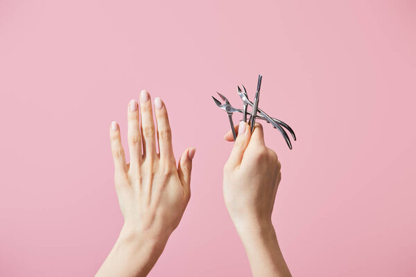 Обрезанный вид женщины, держащей кутикулу толкателя и детенышей изолированы на розовый
