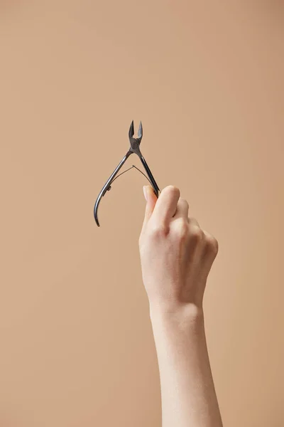 Beskuren Bild Kvinnlig Hand Med Nagelband Nipper Isolerad Beige — Stockfoto