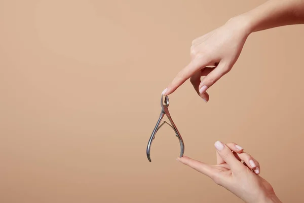 Beskuren Kvinna Som Håller Nagelband Nipper Isolerad Beige — Stockfoto