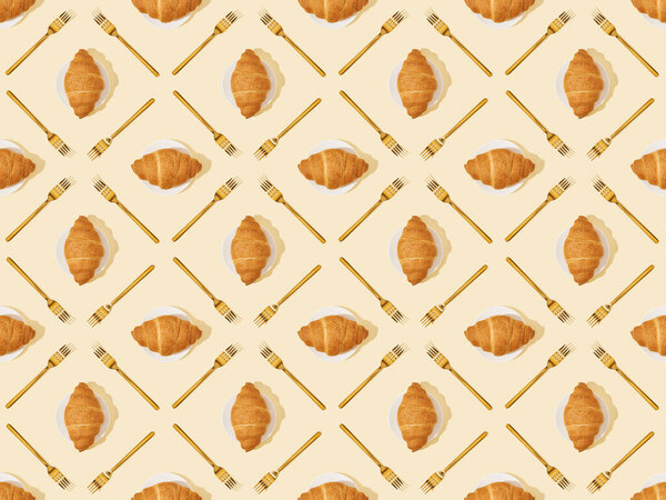 top view of golden forks and croissants on beige, seamless background pattern