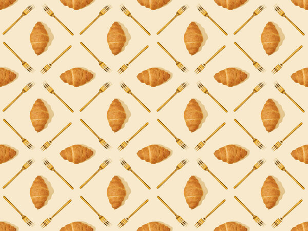 top view of golden forks and croissants on beige, seamless background pattern