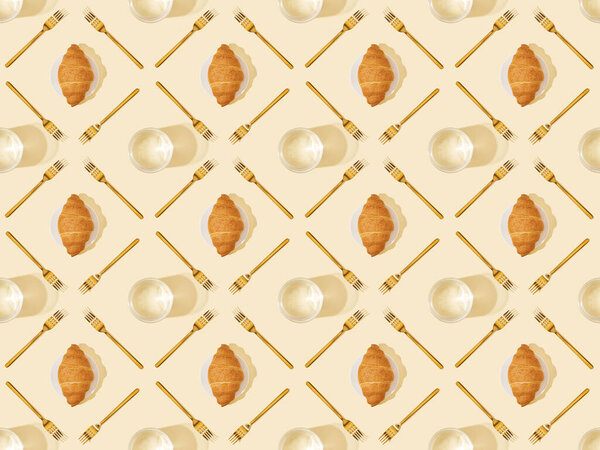 top view of golden forks, glasses of water and croissants on beige, seamless background pattern