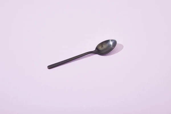 Metal Shiny Black Spoon Violet Background — Stock Photo, Image