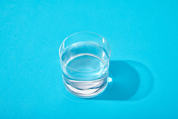 стакан пресной воды на синем фоне
