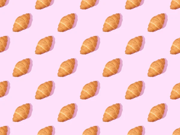 Draufsicht Auf Croissants Auf Rosa Nahtlosem Hintergrundmuster — Stockfoto