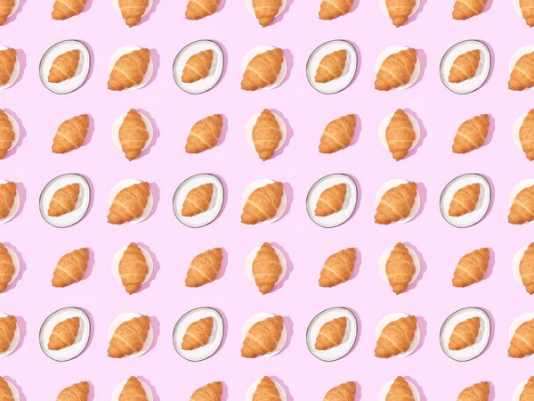 Draufsicht Auf Croissants Auf Tellern Auf Rosa Nahtlosem Hintergrundmuster — Stockfoto