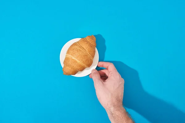 Cropped View Man Holding Fresh Croissant Plate Blue Background — Stock Photo, Image