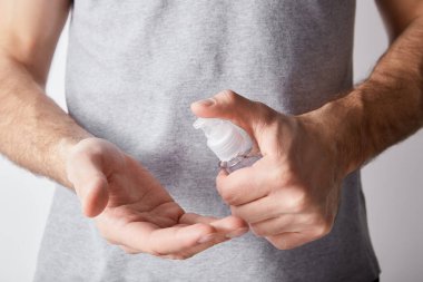 Yetişkin bir adamın şeker şişesinde el dezenfektanı kullanması.