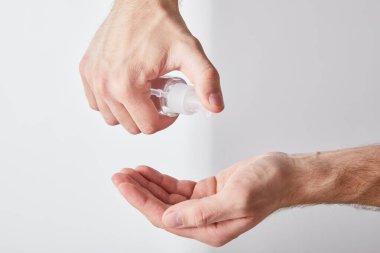Beyaz arka planda el dezenfektanı kullanan yetişkin bir adam görüntüsü