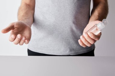 Şişe içinde el dezenfektanı tutan adamın kırpılmış görüntüsü