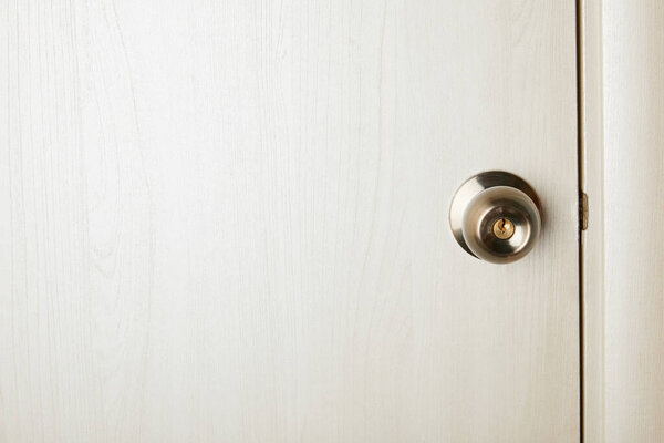 clean white wooden door with metal handle after disinfection