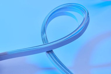 Neon mavi arkaplan üzerindeki renkli kağıt şeritlerin görüntüsünü kapat