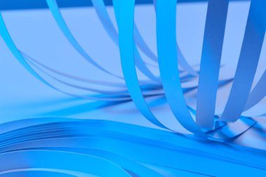 Neon mavi arkaplan üzerindeki kağıt şeritlerin görünümünü kapat