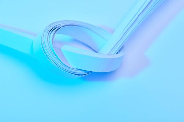 Neon mavi arkaplan üzerindeki kağıt şeritlerin görünümünü kapat