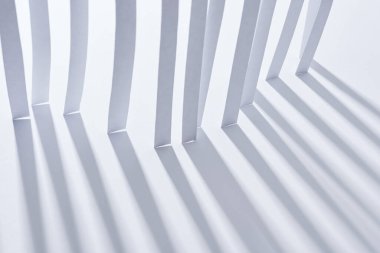 Beyaz arkaplanda gölgesi olan kağıt şeritlerin görünümünü kapat