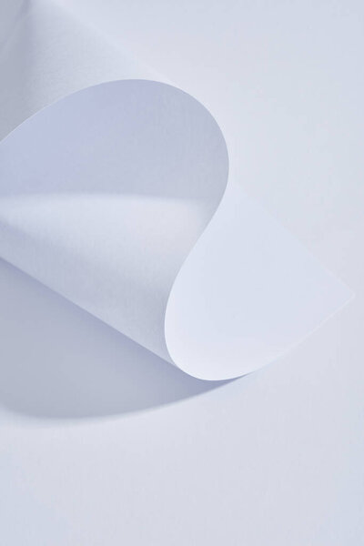 close up view of curved paper sheet on white background