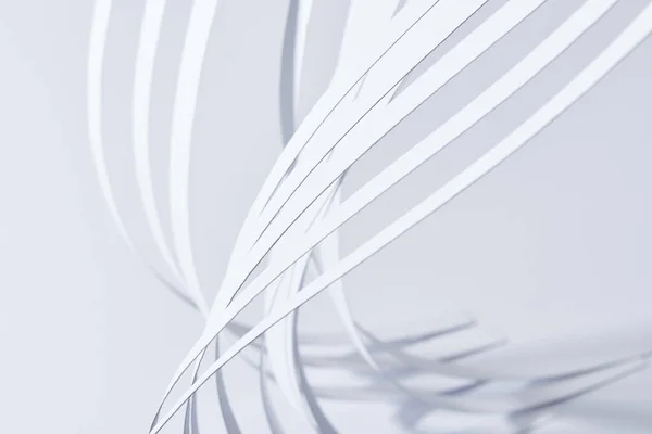 close up view of curved paper stripes on white background