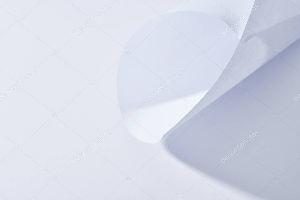 close up view of curved paper sheet on white background