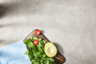 Fesleğen yapraklı, kiraz domatesli ve avokado soslu kareli kumaşın üst görünümü gri.