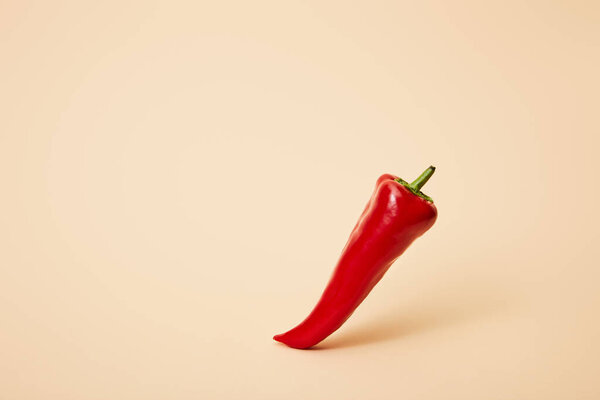 ripe red hot chili pepper on beige with copy space 