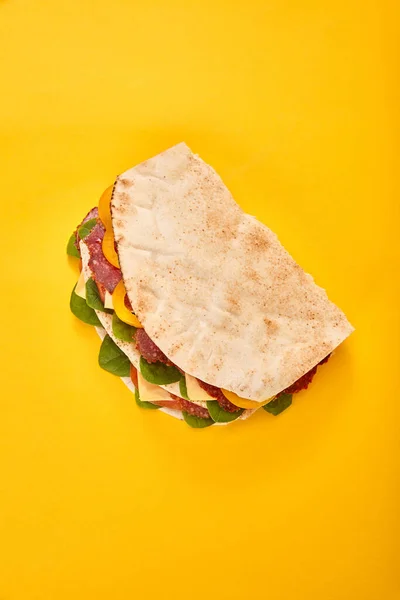 黄色の背景にサラミ チーズの新鮮なサンドイッチの上からの眺め — ストック写真