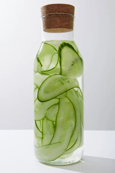 Glazen Fles Met Kurk Gevuld Met Water Gesneden Komkommers Geïsoleerd — Stockfoto