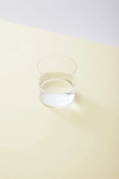 Hoge Hoekweergave Van Glas Met Water Geel Oppervlak Geïsoleerd Grijs — Stockfoto